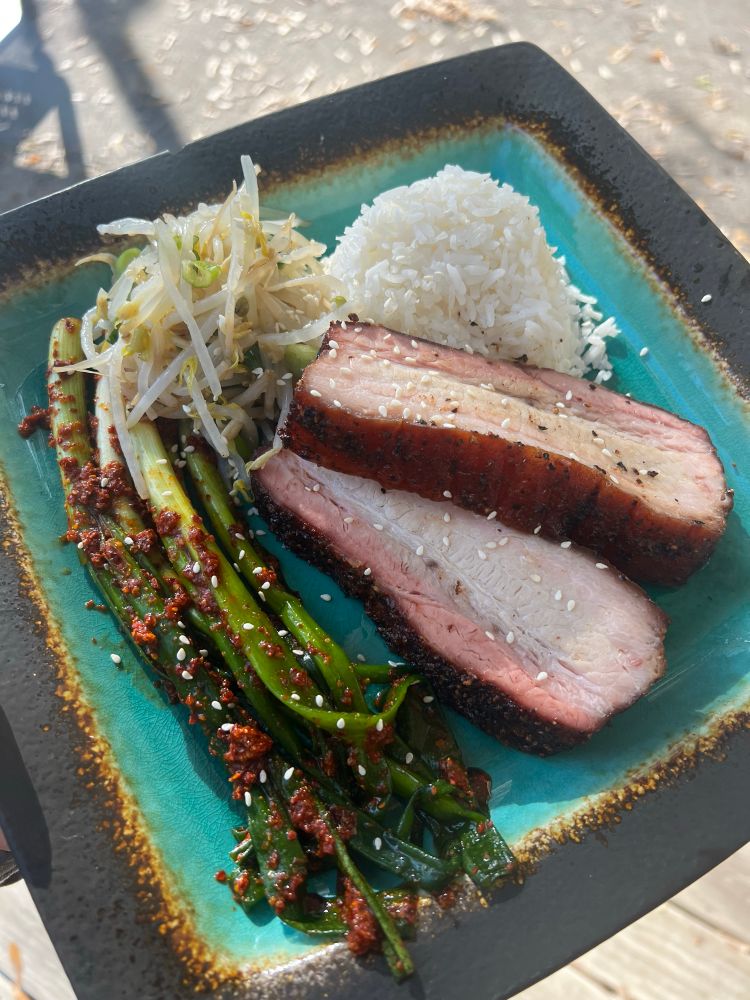 Plate with smoked pork belly, rice, mung bean sprouts, and green onion kimchi 