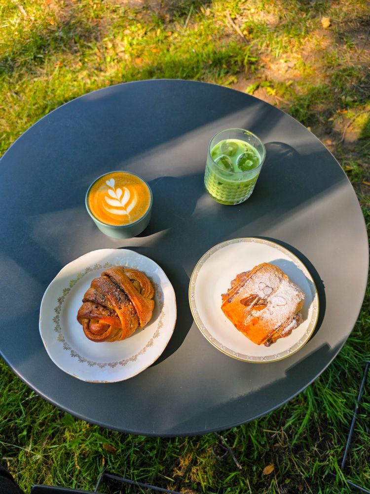 1 cup of coffee, 1 cup of matcha and 2 pastries on a table 