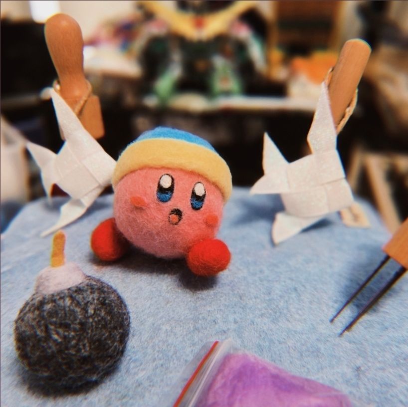 Photo of desk with Felt Kirby and the woven fish ornaments!