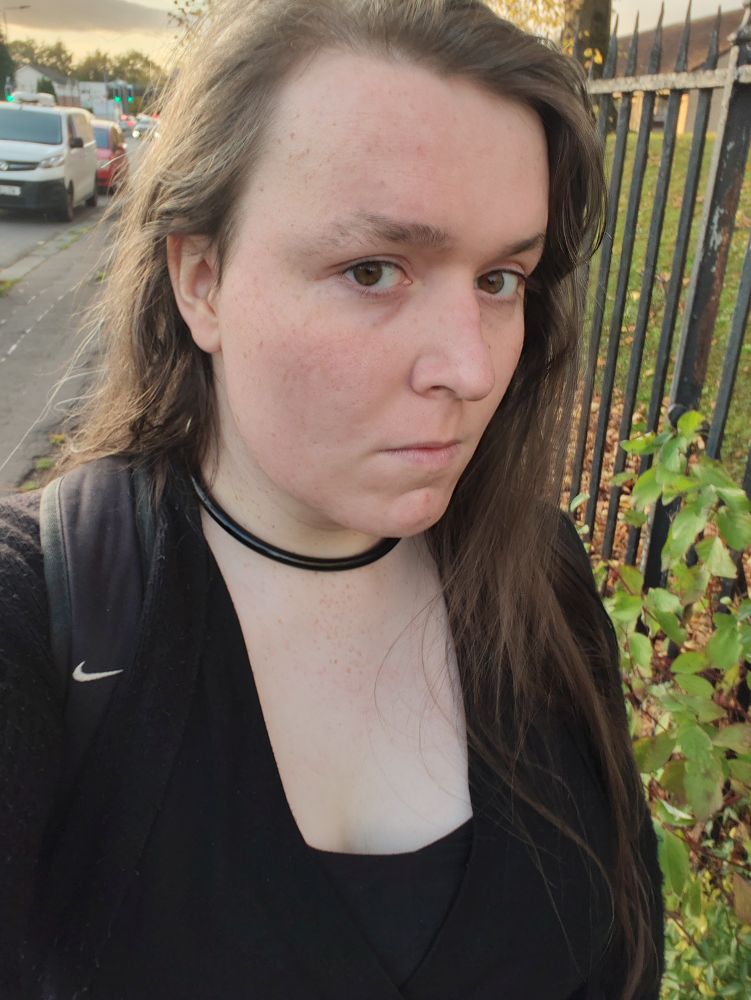 Me in a low-cut black dress looking up at the camera. My hair is brushed back and fluffy