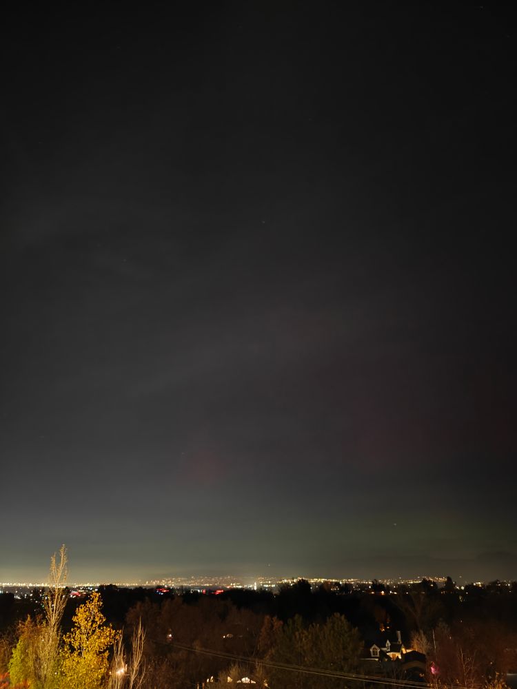 The evening sky with a slight red and green aurora just over the horizon 