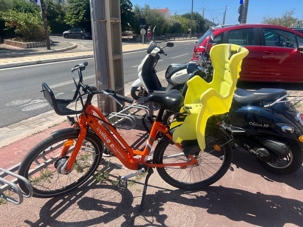 Marseille orange bike with yellow child seat 