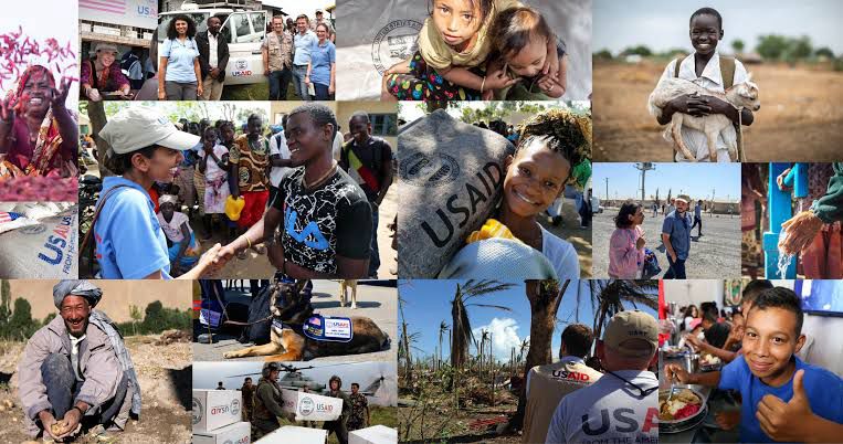 A collage of global humanitarian scenes featuring USAID workers and aid recipients. Images include aid distribution, smiling children, disaster recovery, medical support, and agricultural assistance. Prominent USAID logos appear on boxes, clothing, and supplies, emphasizing relief and human connection across diverse regions.