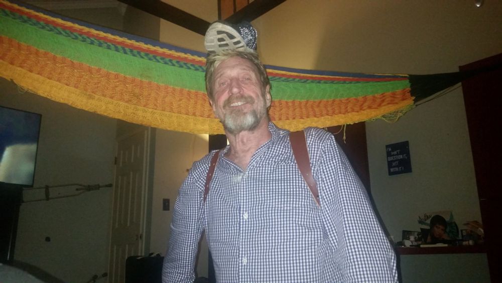 John McAfee with a shoe on his head
