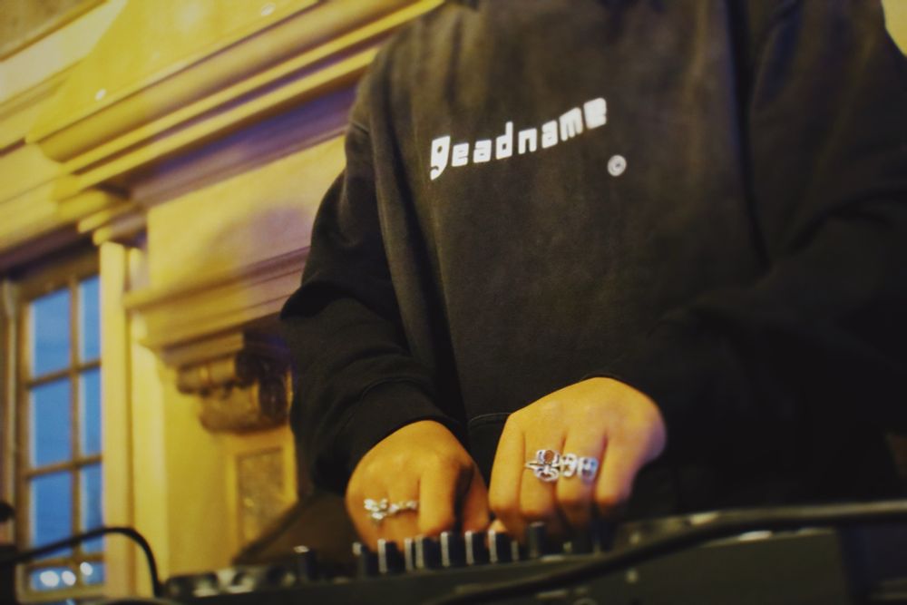 A low angle shot of Kaash djing; her hands adjusting the filter knobs on her deck.