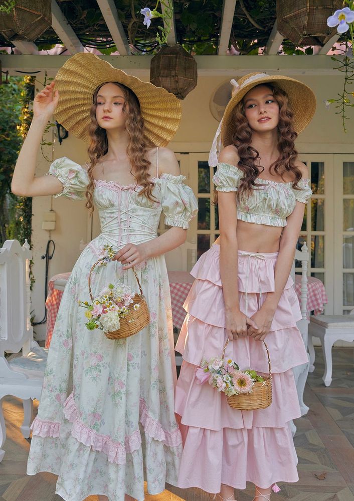 Model wearing the Fleur Poetry Corset Dress from Lacemade; dress, second model’s outfit with a long pink shirt and small top, and photo itself are all not mine; photo from their listing for the dress, which is currently priced at $119 USD; credits to Lacemade and their models 