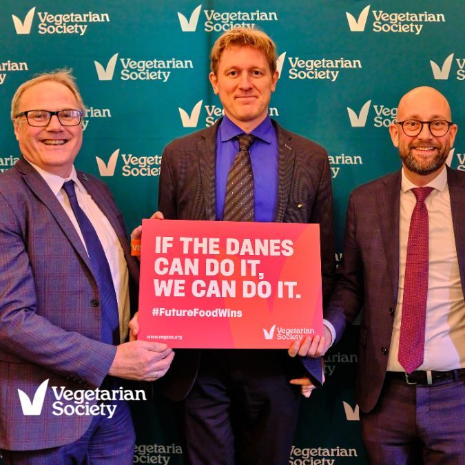 Richard McIlwain, Chief Executive at the Vegetarian Society (left), meeting
Rune-Christoffer Dragsdahl, CEO of the Danish Vegetarian Society, and Rasmus Prehn DMP, former Danish food minister. They are  holding a board which says if the Danes can do it, we can do it.