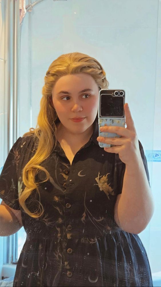 A mirror selfie of chloe in a blonde wig 
