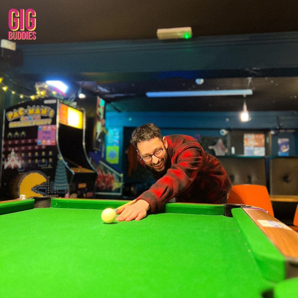 A gig buddy playing pool at the pub.