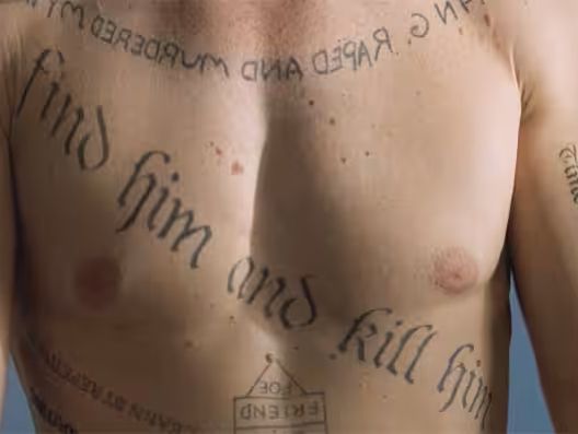 Screenshot of Leonard's chest and upper arm tattoos from the movie Memento