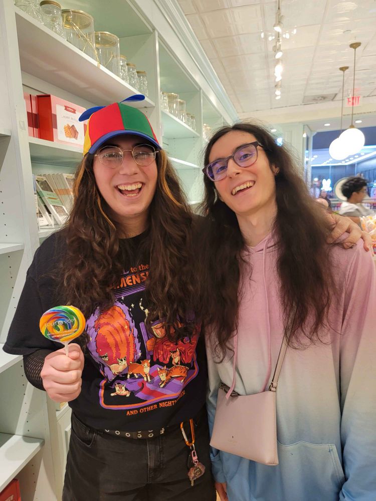 santana and tormi in a candy shop with a rainbow lollipop