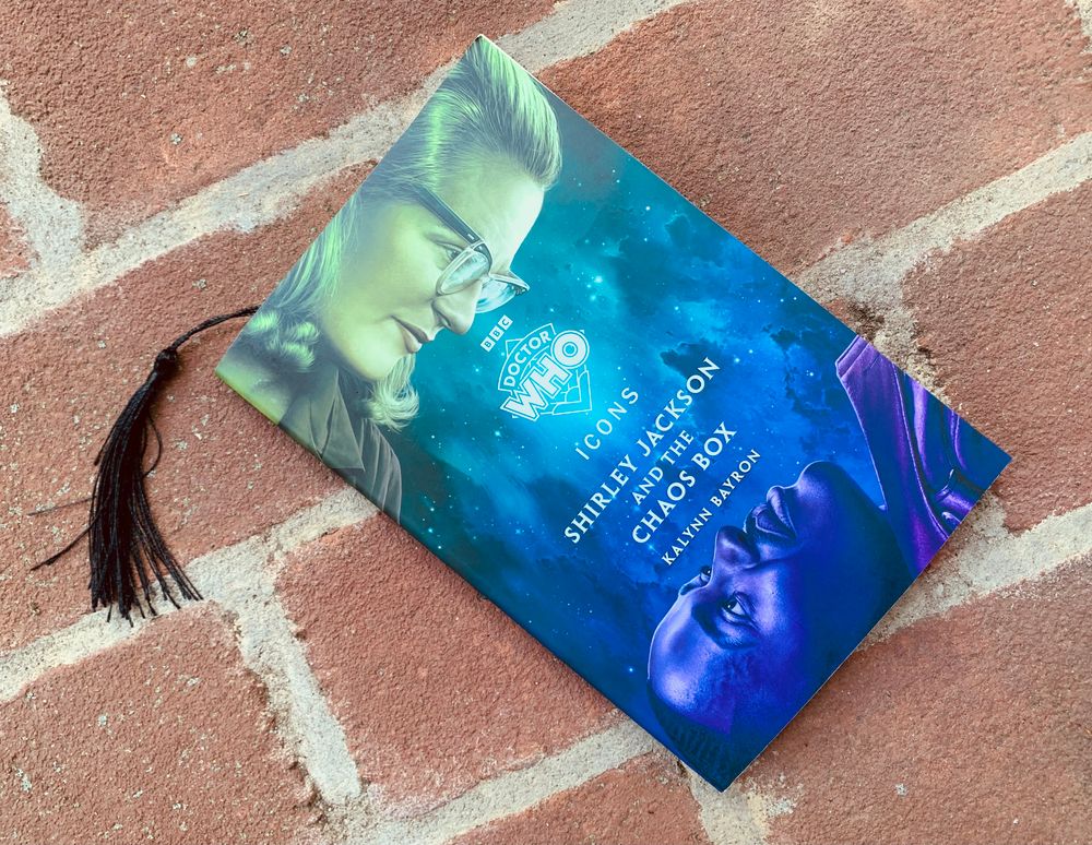 Pictured is Kalynn Bayron's novel Doctor Who: Shirley Jackson and the Chaos Box, with cover art depicting Shirley Jackson and the Doctor looking at each other across space. 