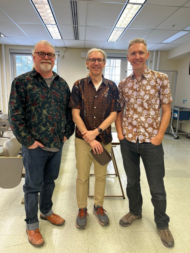 Profs David Coltman, Geoff Wild and Stuart West pose uncertainly in bold patterned shirts.