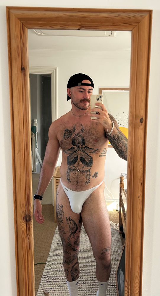 Sorcerer Logan mirror selfie. He’s wearing a white thong, black baseball, and white long sock. In hindsight, he should have picked a hat that matched everything else. I will speak to him about this later 