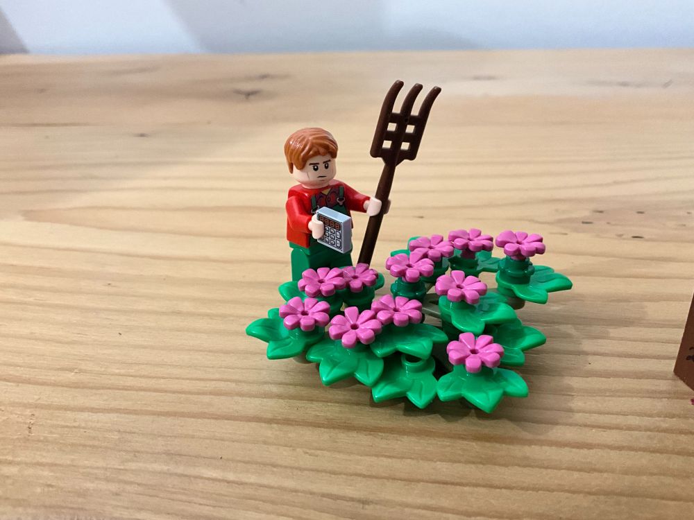 Légo Mendel devant un parterre de fleurs