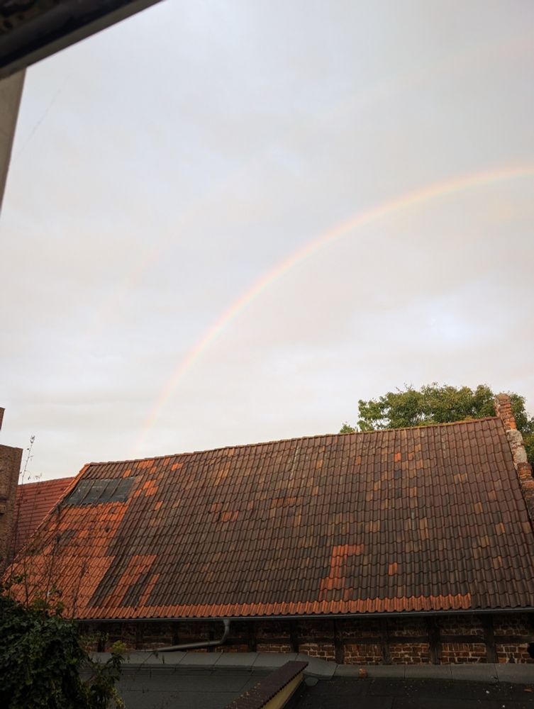 Regenbogen linke Hälfte über rotem Dach - ein Hauch zweiter Bogen drüber 