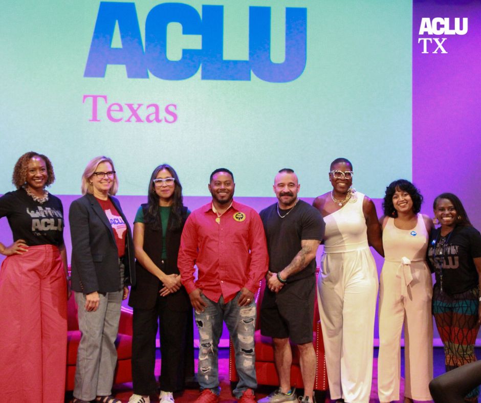 image of 8 people smiling and standing in a line on a stage in front of a screen that reads ACLU of Texas.