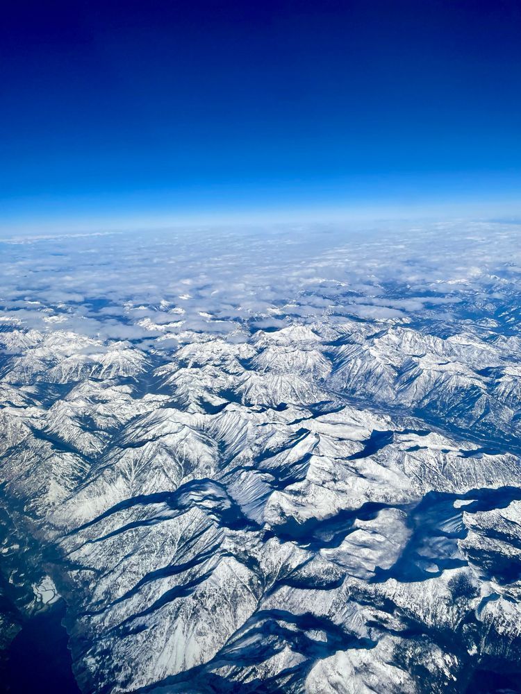 Snow-capped mountains seen from a plane window.