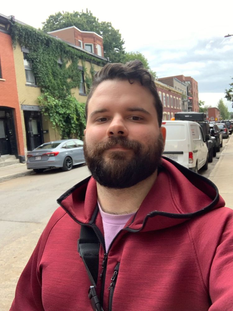 Selfie during a little walk. Behind me one of the buildings is covered in vegetation.