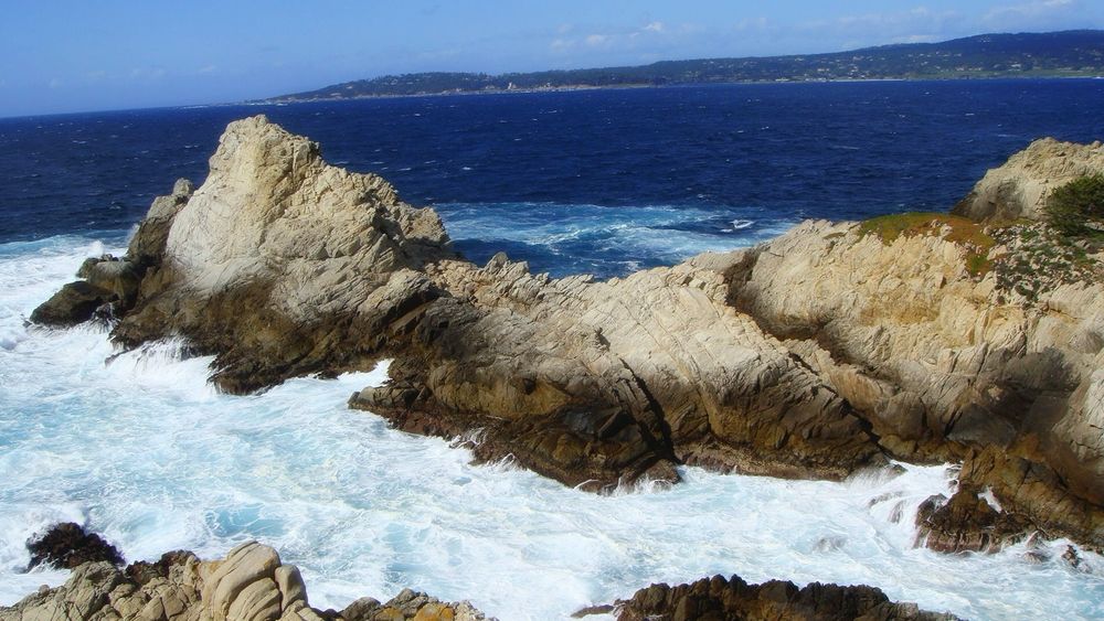 Surf breaking on the rocks along the coast of the Pacific Ocean in Northern California.