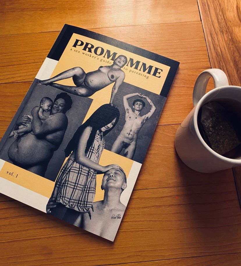 A cup of tea is next to a magazine, featuring the nude bodies of parents on the cover, some with their offspring, celebrating parents who are also sex workers 