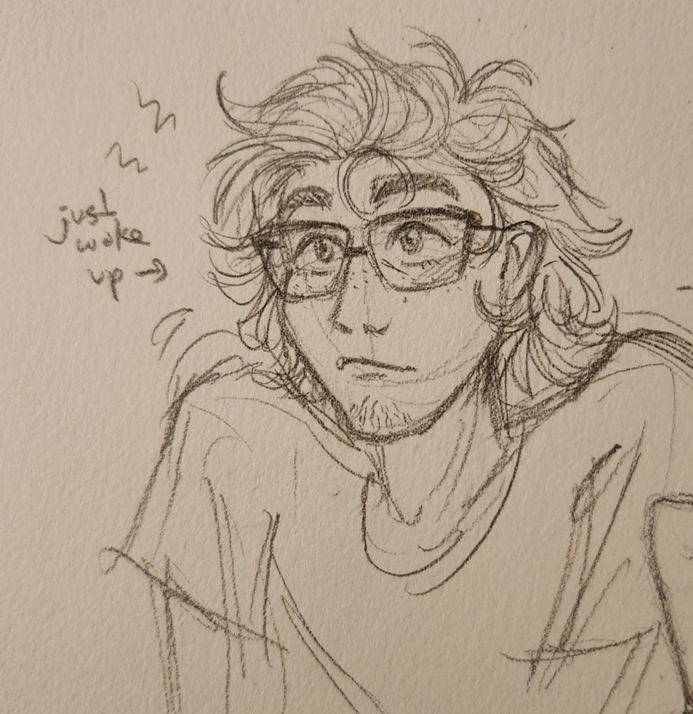 A pencil sketch of the same male character from before in a 3/4 view, looking up. He has messy bedhead and a note beside him reads "just woke up" with an arrow pointing at him. He wears an oversized t-shirt, and his glasses, and he has a bit of scruff on his chin.