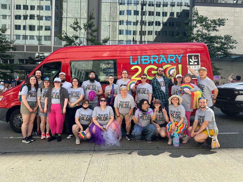 KCLS staff at the Seattle Pride Parade in front of the Library2Go! bus.