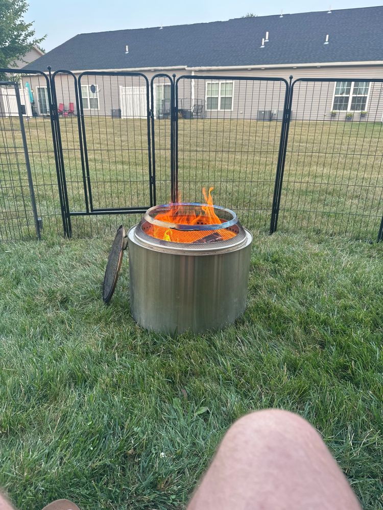 A fire pit with a fire outside in a backyard 