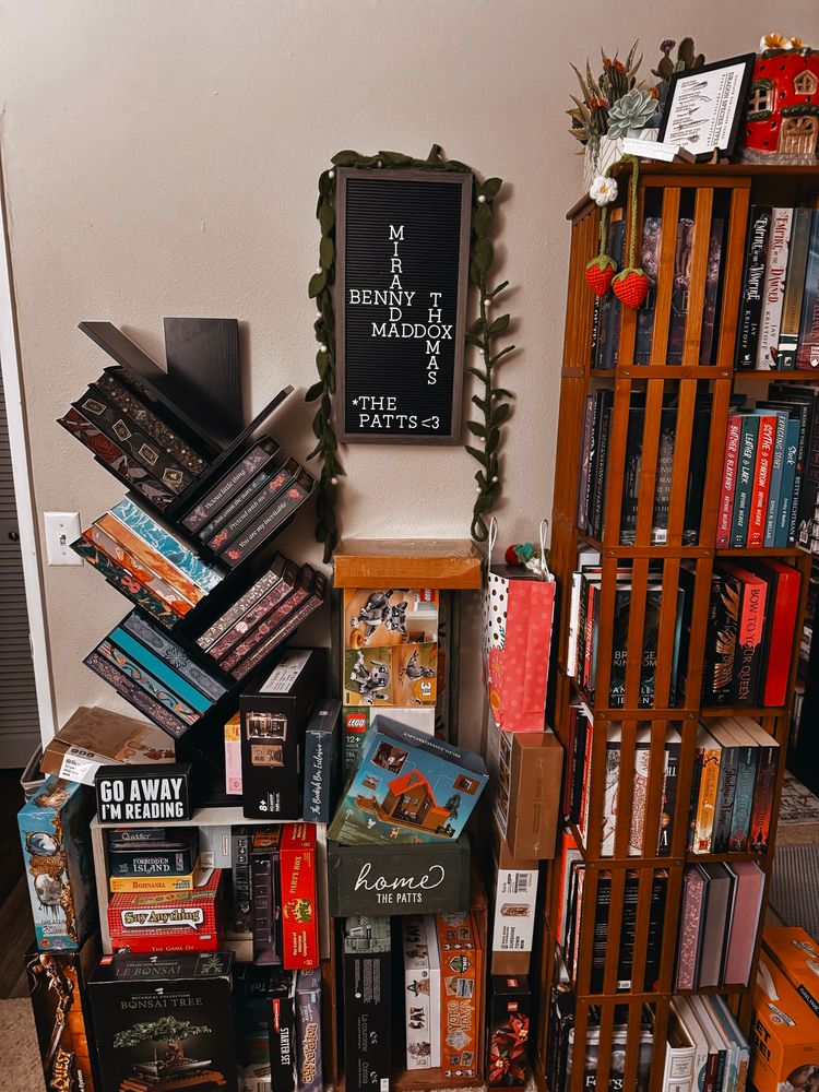 Photo of two more bookshelves that are surrounded by boardgames and unbuilt legos 