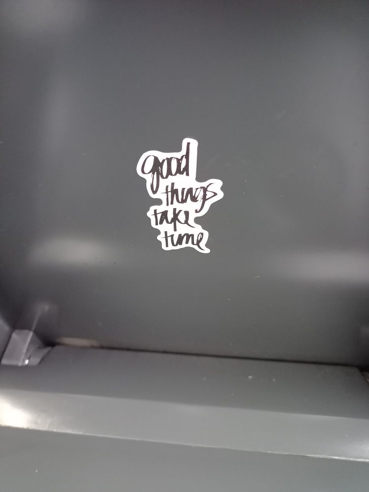Sticker on back of train seat reads "good things take time"