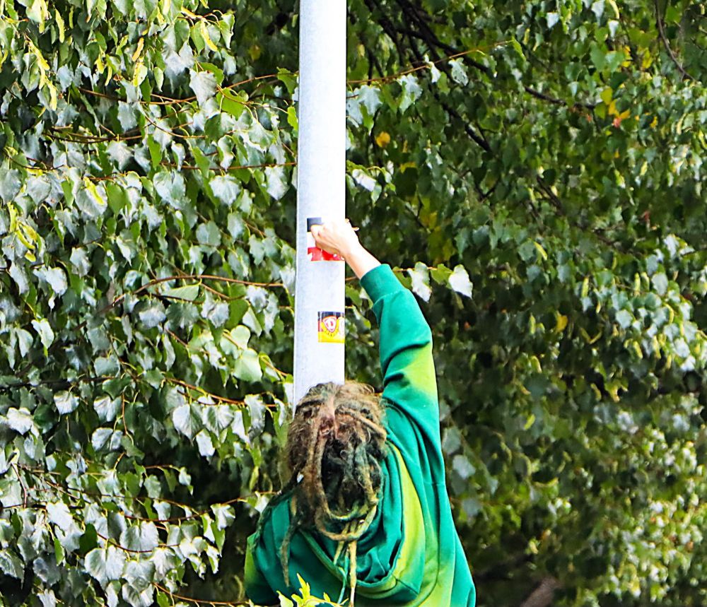 Nähe der Maria-und-Martha-Kirche in Bautzen entfernt eine Person einen schwarz-weiß-roten Sticker, der Erkennungszeichen der rechtsextremen Szene ist.