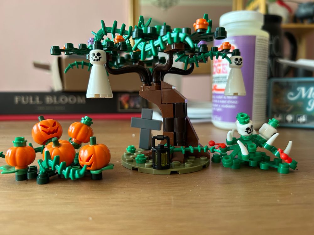 A Lego set of a spooky tree, some pumpkins, and some ghosts. 