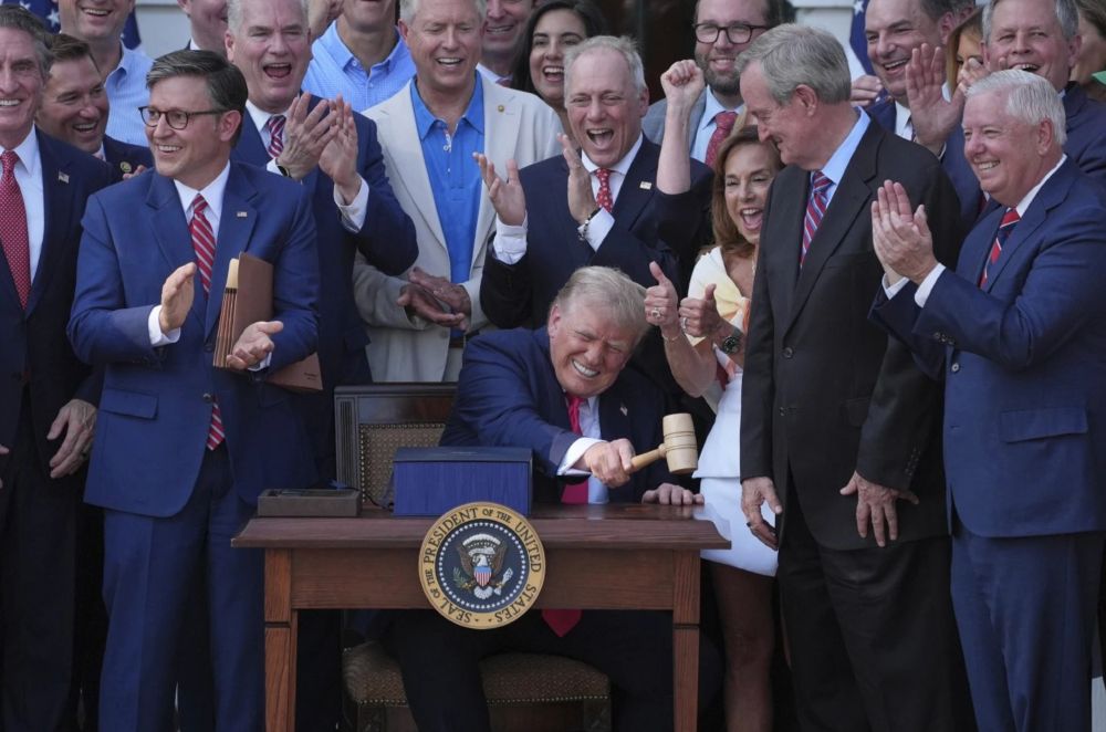 Photo of Trump surrounded by cheering sycophants nearly wetting themselves with glee as he signs legislation screwing over most of the people in the USA as well as millions in the rest of the world