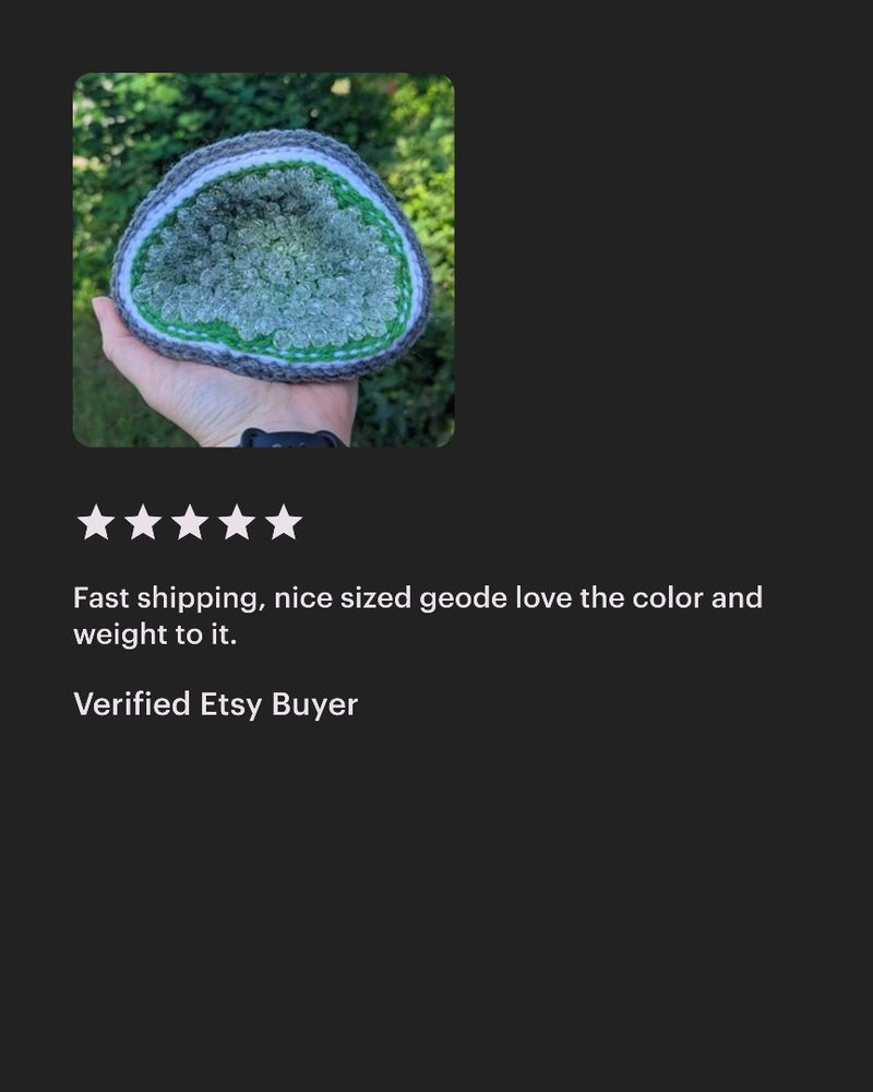 Photo of a handmade crocheted geode with a gray, white, and green exterior and sparkling  crystal-like beads inside. The geode is held in a hand outdoors against a background of greenery. Below the image is a five-star Etsy review that reads: ‘Fast shipping, nice sized geode love the color and weight to it.’  Verified Etsy Buyer. 