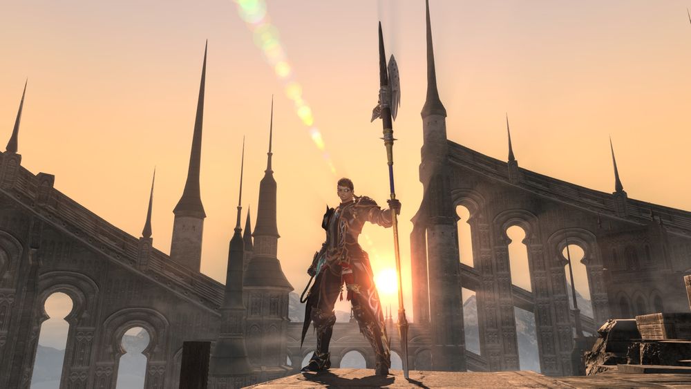 Fin standing at the edge of a crumbled parapet in Foundation, the lower section of Ishgard. He's wearing his customary dark plate armor and holding his halberd at the ready, with a big cheesy grin.