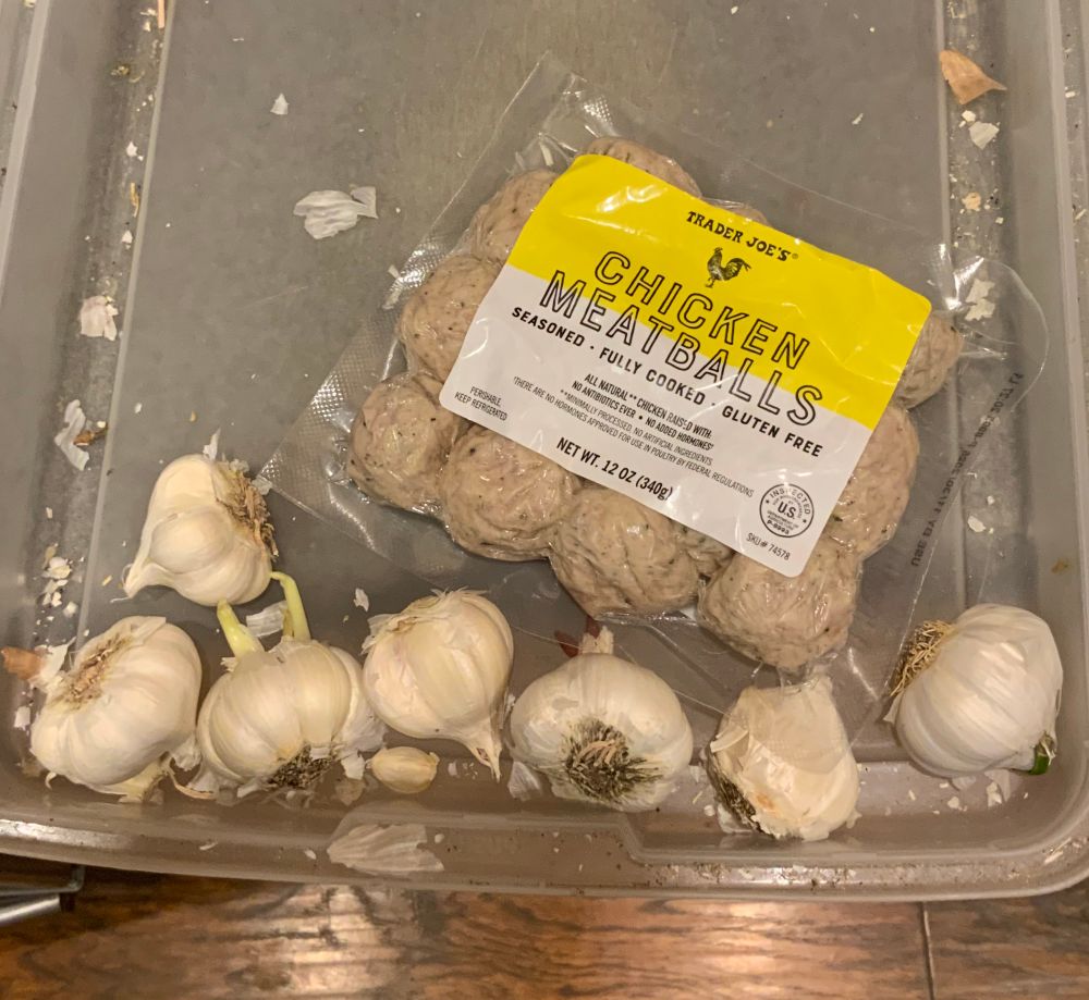 plastic refrigerator tray that contains seven heads of garlic and a package of Trader Joe's chicken meatballs 