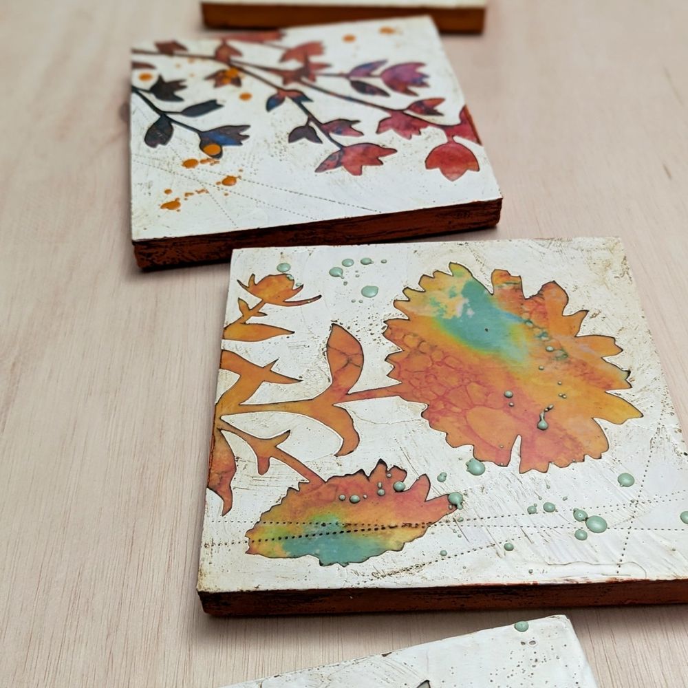 Image shows original artwork of plants and flowers in bright colors with a lot of texture. Material is encaustic wax and creates beautiful tactile textures.