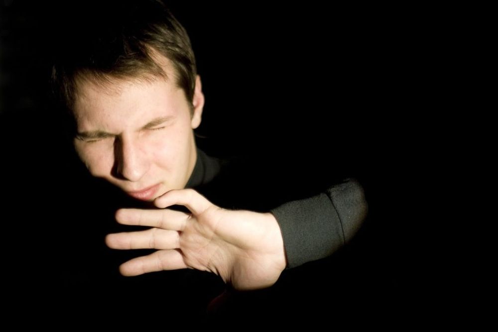 man being blinded by bright light, presumably someone using light mode on their devices 