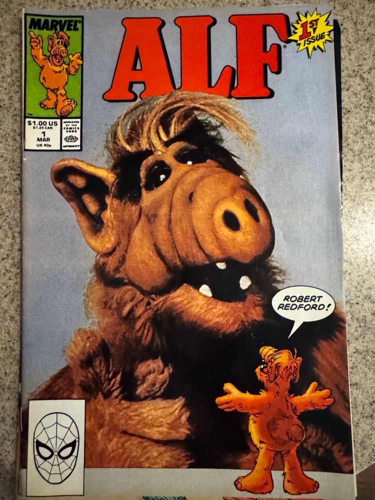 The cover of Alf #1, a comic book. On the cover, Alf, a muppet who resembles a warthog-elf hybrid. A smaller ALF regards his own portrait and declares: “Robert Redford!”