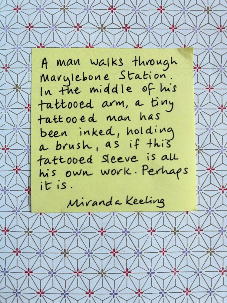 A man walks through Marylebone Station. In the middle of his tattooed arm, a tiny tattooed man has been inked, holding a brush, as if this tattooed sleeve is all own his work. Perhaps it is.
