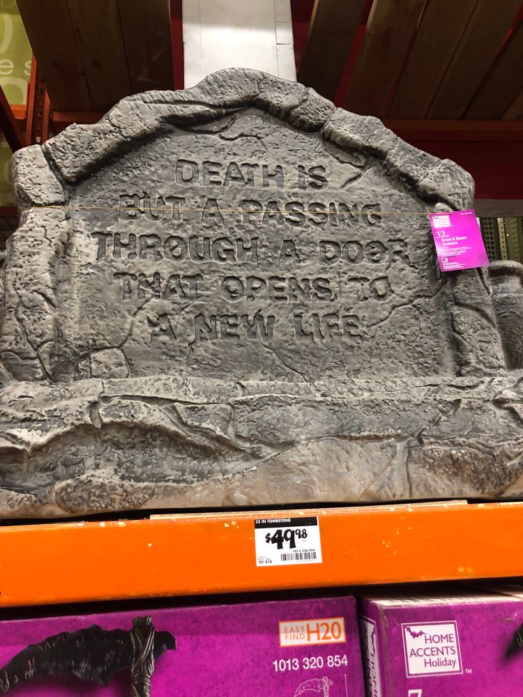 Large plastice tombstone for sale with the misguided inscription DEATH IS BUT A PASSING THROUGH A DOOR THAT OPENS TO A NEW LIFE