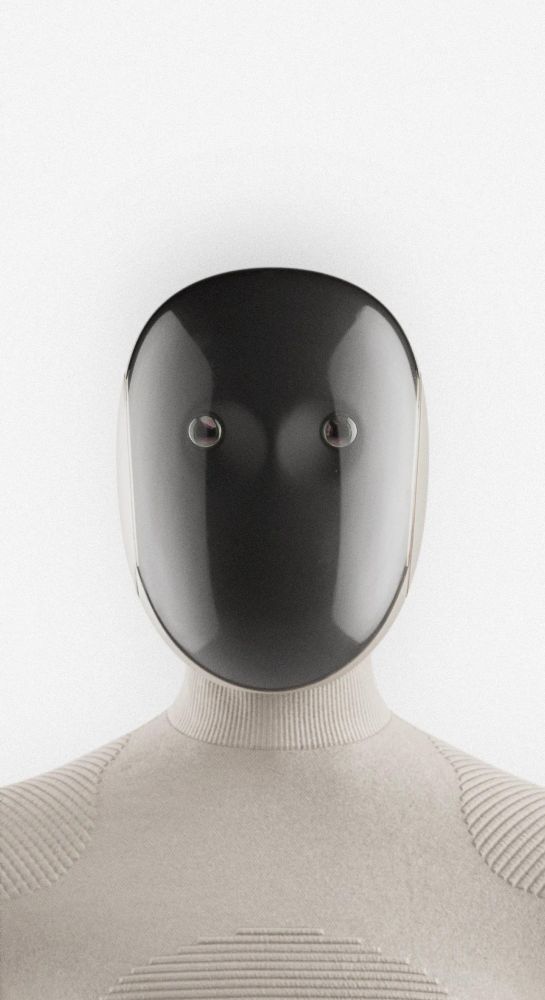 The head and shoulders of a home helper robot called Neo Gamma. It's face is glass with two, eerie robotic eyes peering out from a black abyss.