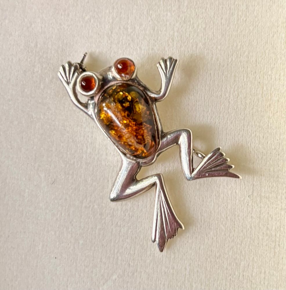 Silver brooch in the form of a jumping frog, body and eyes made from Baltic amber. 