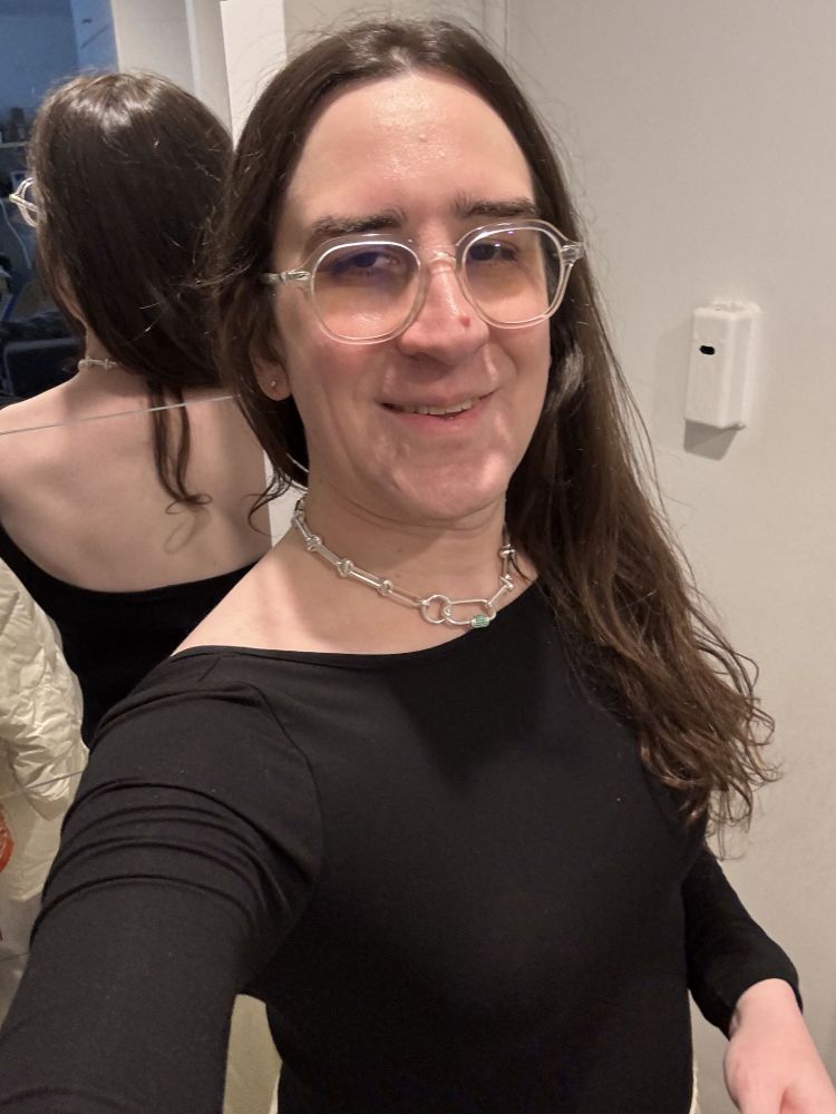 me in a cool black dress.  back visible in the mirror.