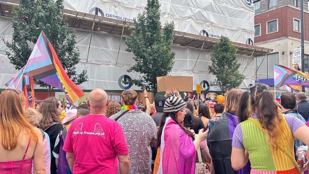 A crowd of people watching the Leeds Pride parade.
