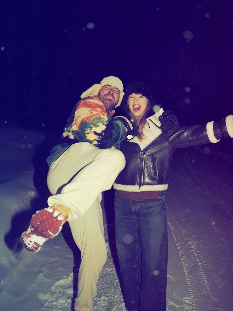 Taylor and Travis in the snow at night. Travis left, is wearing a colourful jumper and white trousers and kicking his left foot in the direction of the camera. Taylor right, is wearing a black jacket and denim jeans. 