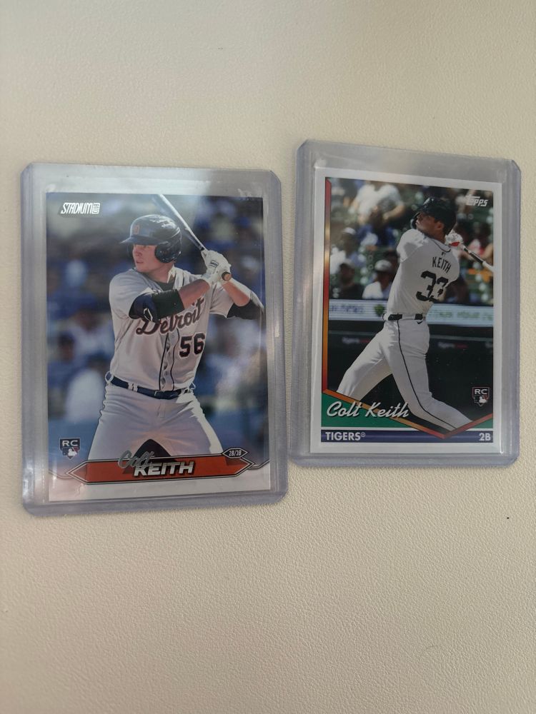 Two baseball cards, depicting a Detroit Tigers player batting. The man is holding a bat over his shoulder in one and wearing a white outfit that has Detroit written across it, and the other photo has the same man with the bat being swung wearing the same white jersey. The man’s name is Colt Keith, and these are the first cards of his