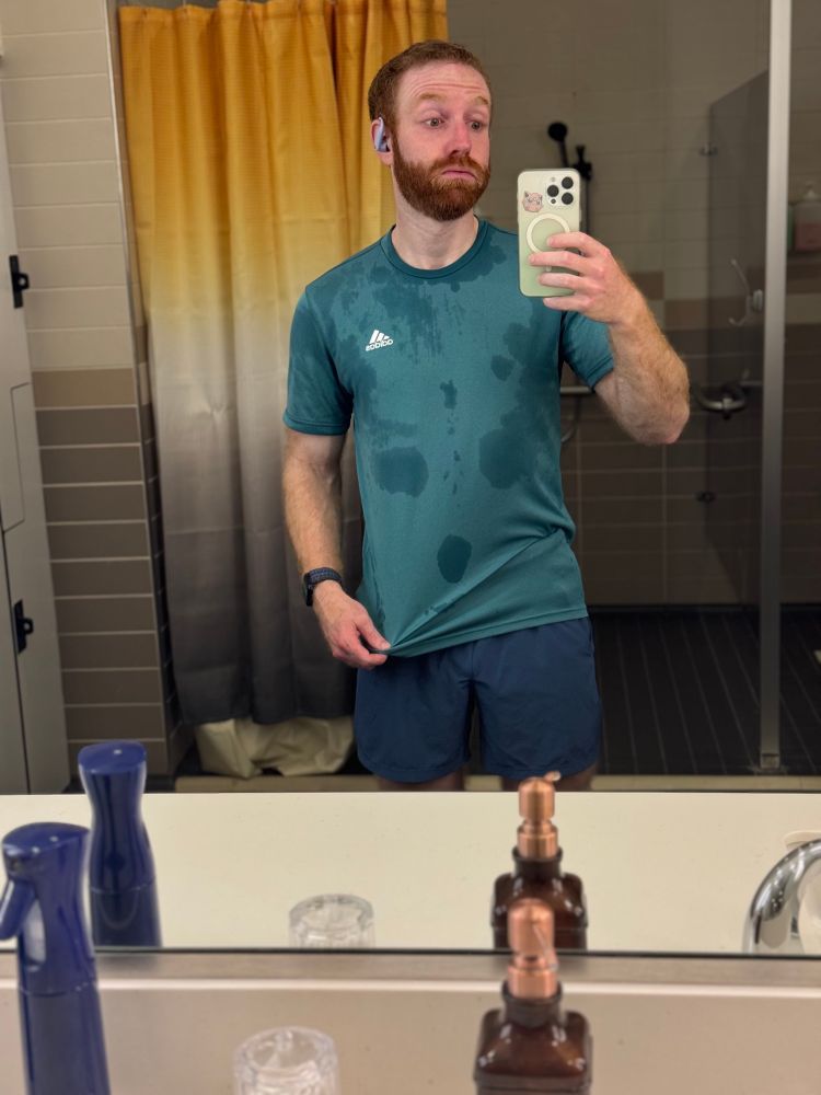 Bearded ginger man locker room mirror selfie, sweaty adidas teal workout shirt. 