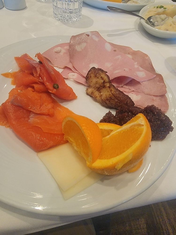 Food from Fogo de Chao. Salmon, oranges, cheese, fig paste, some type of ham, and roasted plantain.