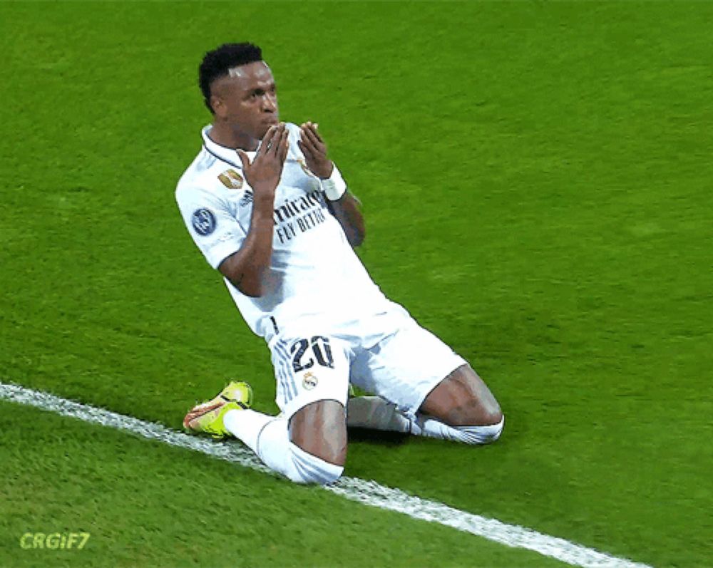 a soccer player wearing a fly emirates jersey is kneeling down on the field